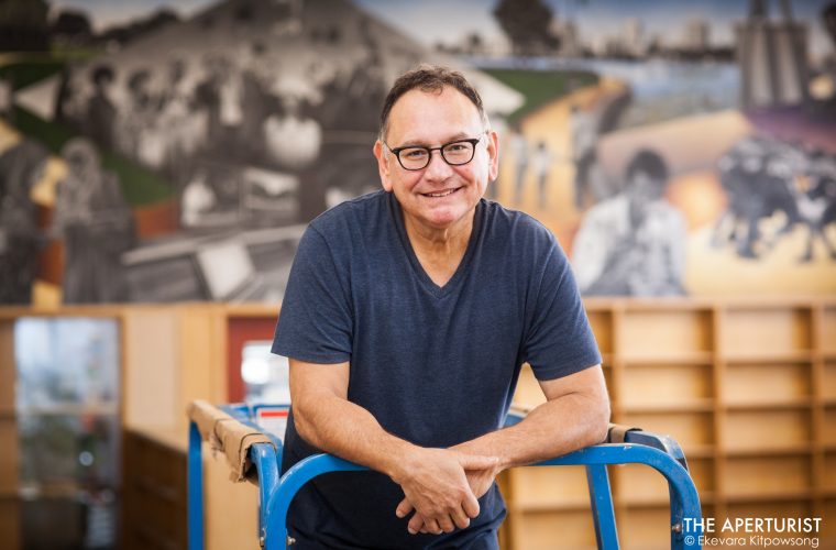 Oakland muralist Daniel Galvez poses for a portrait in front of his new mural "Mack Town Rising" on a wall in The McClymonds Library Innovation Technology Center at McClymonds High School in Oakland, Calif. on Wednesday, Jan. 9, 2019. (Photo by Ekevara Kitpowsong/Current SF)