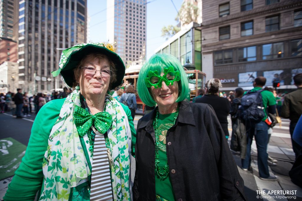 Two women wear green outfits as they walk on Market Street during the 168th annual San Francisco St. Patrick’s Day Parade on Saturday, March 16, 2019, in San Francisco, Calif. (Photo by Ekevara Kitpowsong/Current SF)