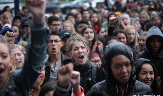 Students raise their fists and chant in solidarity as they gather in front of San Francisco City Hall to protest against gun violence on the one-month anniversary of the high school shooting that a gunman killed 17 people at Marjory Stoneman Douglas High School in Parkland, Florida, Wednesday, March 14, 2018, San Francisco, Calif. (Photo by Ekevara Kitpowsong/Current SF)